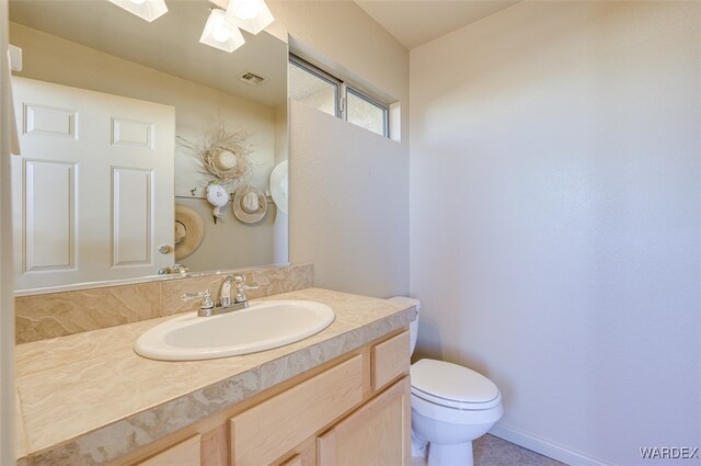 half bathroom featuring toilet, vanity, baseboards, visible vents, and a ceiling fan