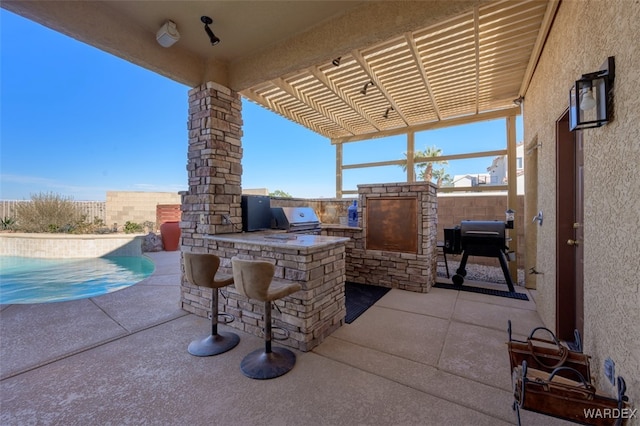 view of patio / terrace featuring an outdoor kitchen, a fenced backyard, an outdoor bar, a grill, and a pergola