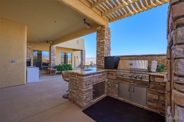 view of patio / terrace with a pergola, exterior kitchen, and area for grilling