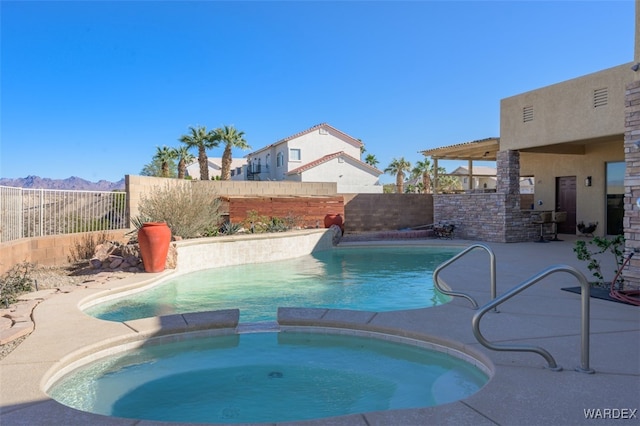 view of swimming pool featuring a patio area, a fenced backyard, and a pool with connected hot tub