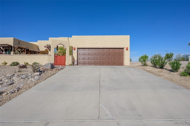 southwest-style home with driveway, fence private yard, an attached garage, and stucco siding