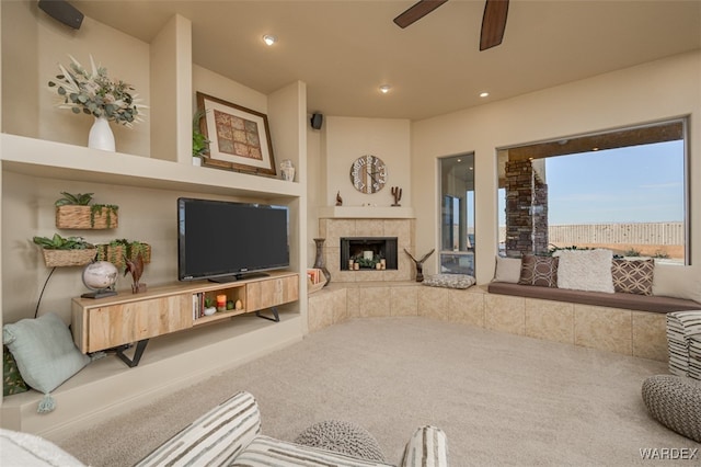 living room featuring a ceiling fan, carpet, a fireplace, and recessed lighting