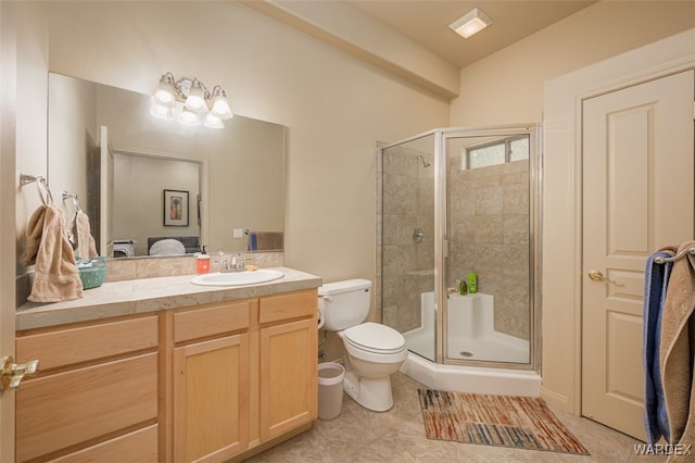 bathroom featuring toilet, tile patterned floors, a shower stall, and vanity