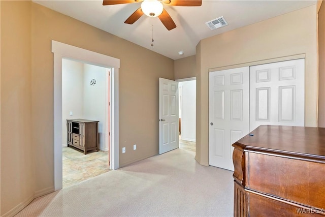 bedroom featuring ceiling fan, light colored carpet, visible vents, baseboards, and a closet