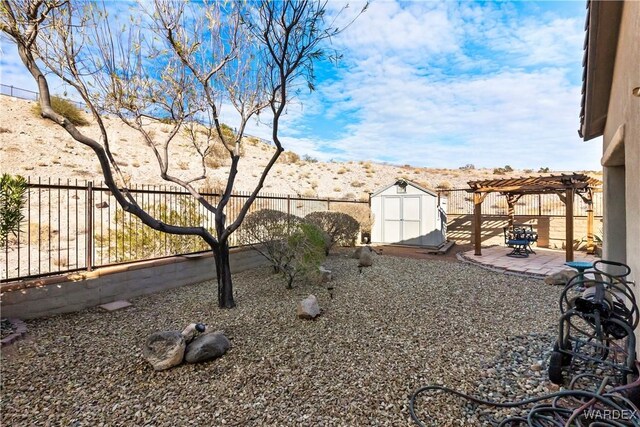 view of yard with an outbuilding, a storage unit, a patio area, a pergola, and a fenced backyard