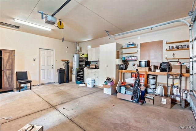 garage featuring water heater and a garage door opener