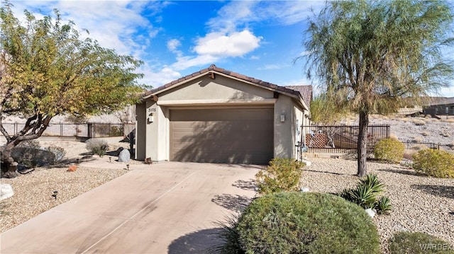 exterior space with a garage, fence, driveway, and stucco siding