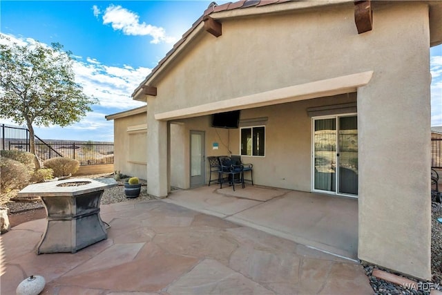 view of patio with a fire pit and fence