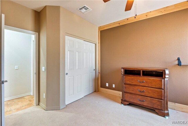 bedroom with light carpet, baseboards, visible vents, and a closet