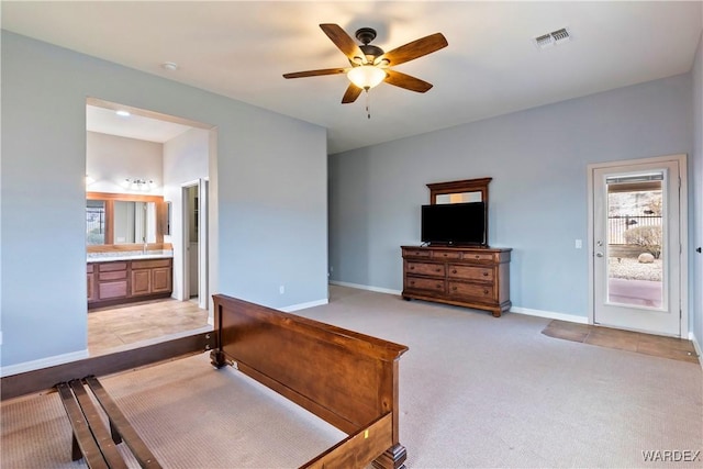 bedroom with light carpet, baseboards, visible vents, a ceiling fan, and ensuite bathroom