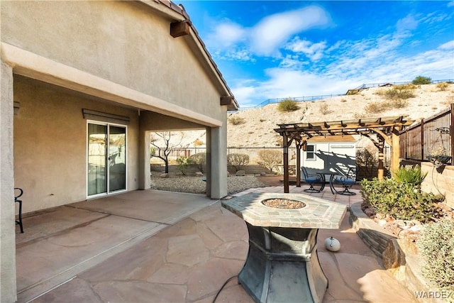 view of patio / terrace featuring an outdoor fire pit, fence, and a pergola