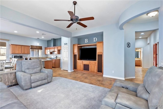 living room featuring light tile patterned floors, arched walkways, recessed lighting, a ceiling fan, and baseboards