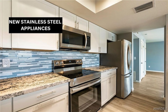 kitchen featuring white cabinets, appliances with stainless steel finishes, visible vents, and tasteful backsplash