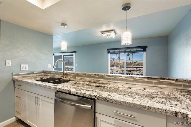 kitchen featuring a sink, light stone countertops, white cabinets, and dishwasher