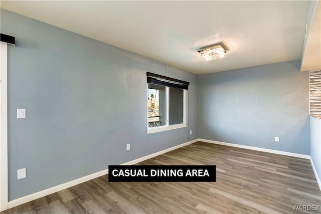 unfurnished room featuring baseboards and wood finished floors