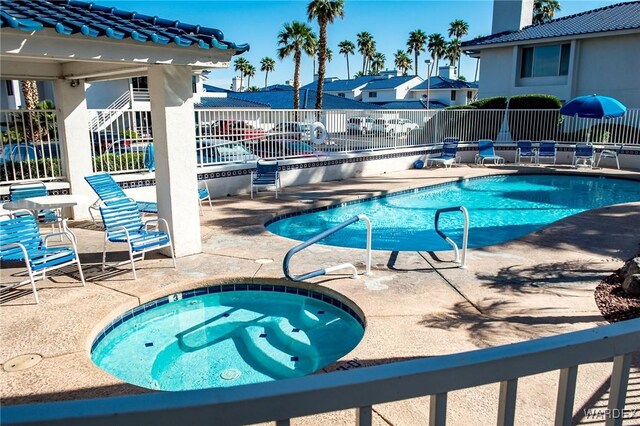 pool with a residential view, a patio area, fence, and a hot tub