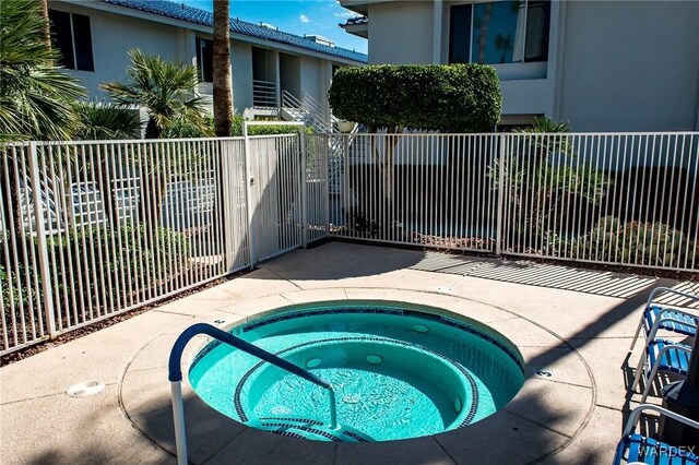 view of swimming pool with a community hot tub and fence