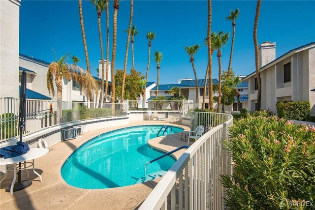 community pool with fence and a residential view