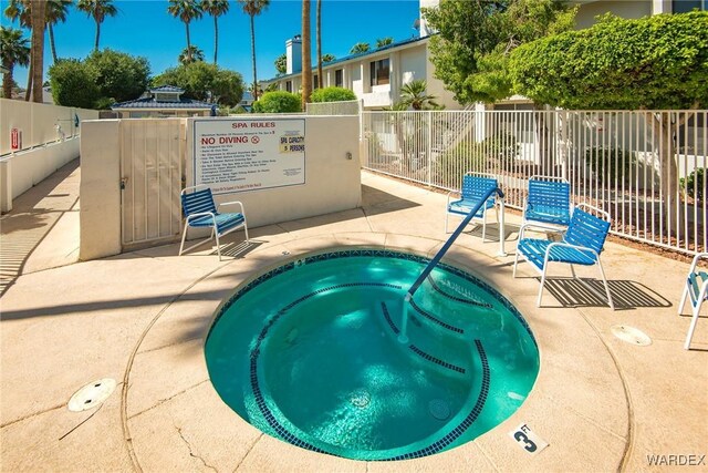 view of pool featuring a patio area, a hot tub, and fence