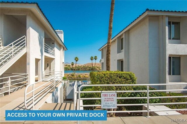 exterior space featuring a water view and stucco siding