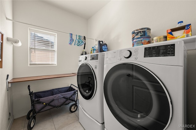 clothes washing area with laundry area, light tile patterned floors, and separate washer and dryer