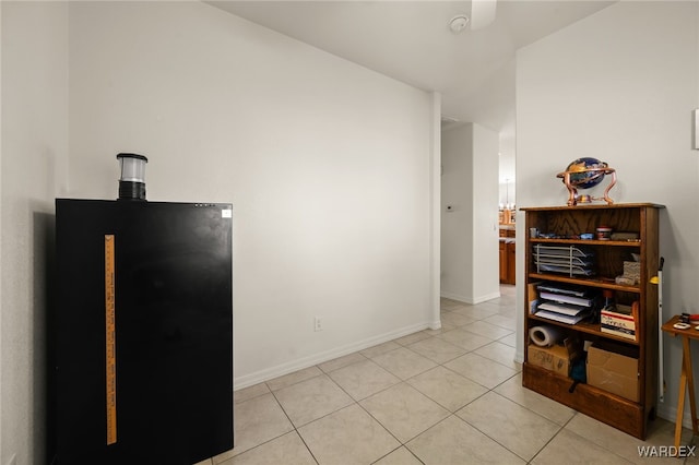 kitchen featuring light tile patterned floors, baseboards, and freestanding refrigerator