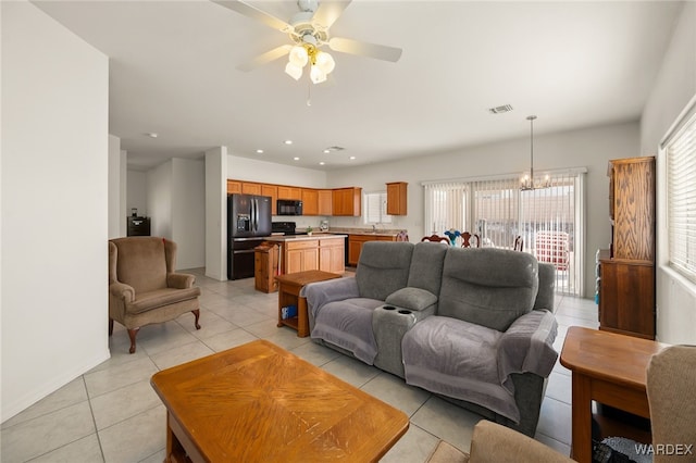 living area featuring ceiling fan with notable chandelier, light tile patterned flooring, visible vents, and recessed lighting