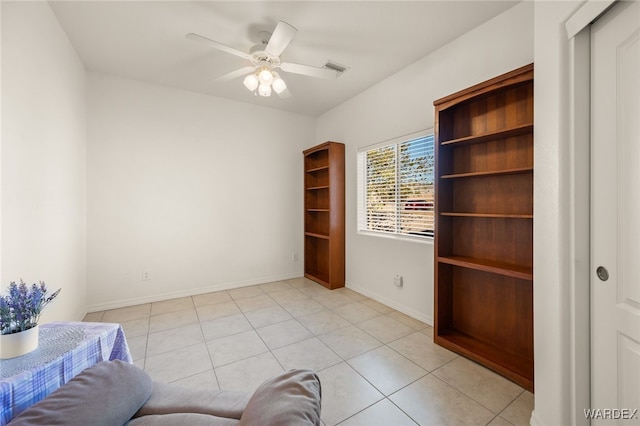 unfurnished room with ceiling fan, light tile patterned flooring, and baseboards