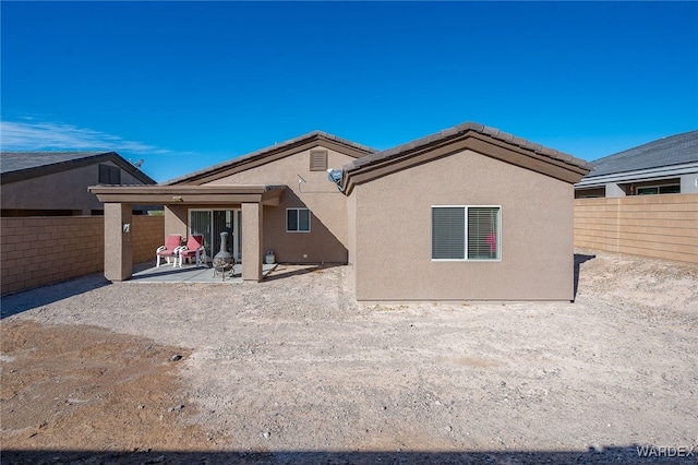 back of property featuring a fenced backyard, a patio, and stucco siding