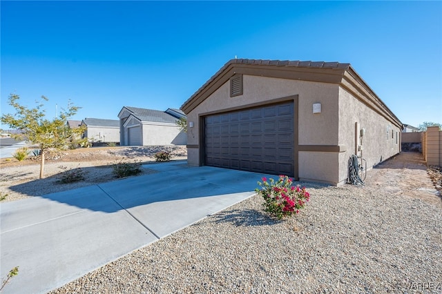 view of property exterior with driveway, an attached garage, and stucco siding