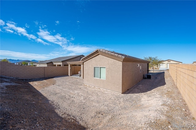 view of home's exterior with central air condition unit, a fenced backyard, and stucco siding