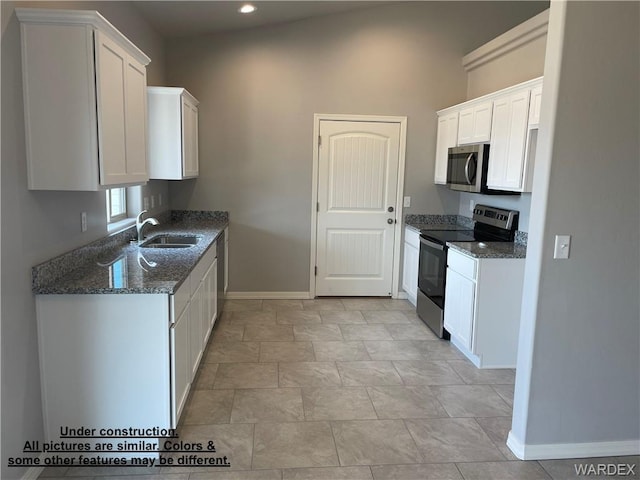 4939 N Famoso Dr, Kingman, AZ 86409 - kitchen with stainless steel appliances, a sink, baseboards, dark stone countertops, and white cabinetry