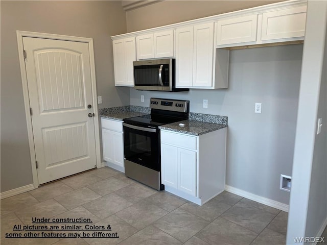 4939 N Famoso Dr, Kingman, AZ 86409 - kitchen featuring appliances with stainless steel finishes, dark stone countertops, white cabinets, and baseboards