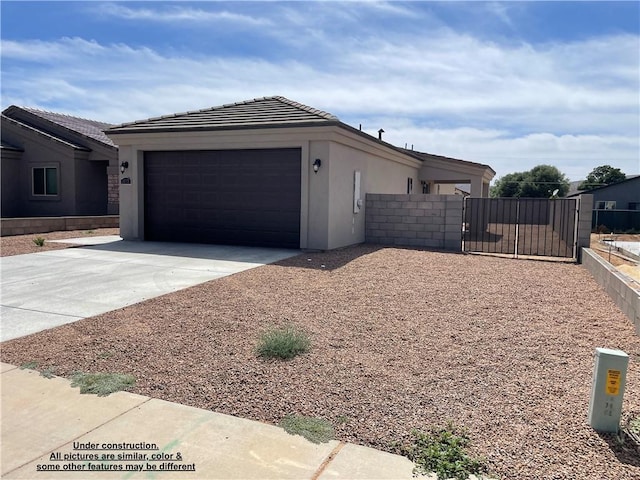 4939 N Famoso Dr, Kingman, AZ 86409 - view of home's exterior featuring concrete driveway, a garage, stucco siding, a gate, and a tiled roof