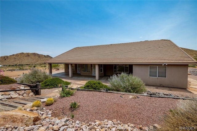 back of house featuring a patio area, a mountain view, and stucco siding