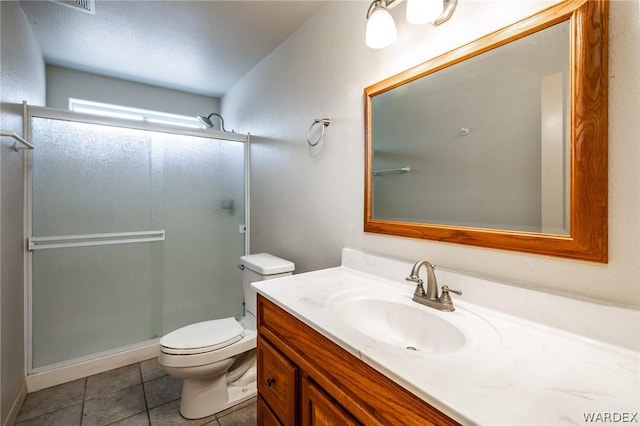 full bathroom featuring toilet, tile patterned flooring, vanity, and a shower with door