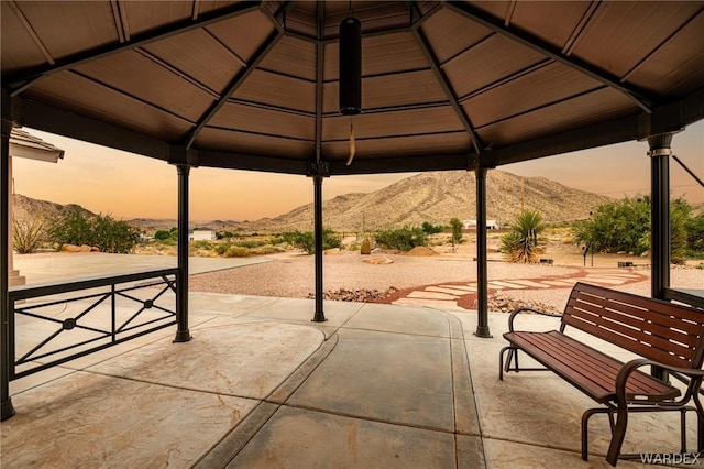 patio terrace at dusk featuring a mountain view and a gazebo