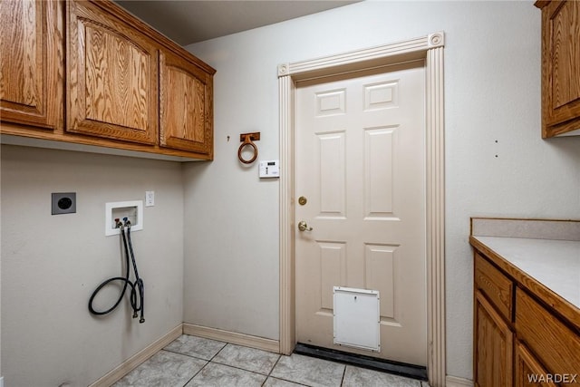 clothes washing area featuring cabinet space, light tile patterned floors, baseboards, hookup for a washing machine, and hookup for an electric dryer