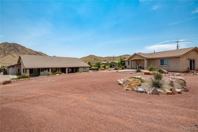 ranch-style house featuring a mountain view and stucco siding