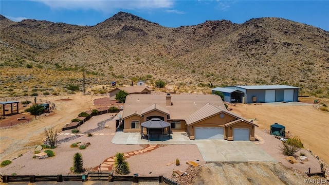 view of front of property featuring driveway, a tiled roof, a mountain view, and a gazebo