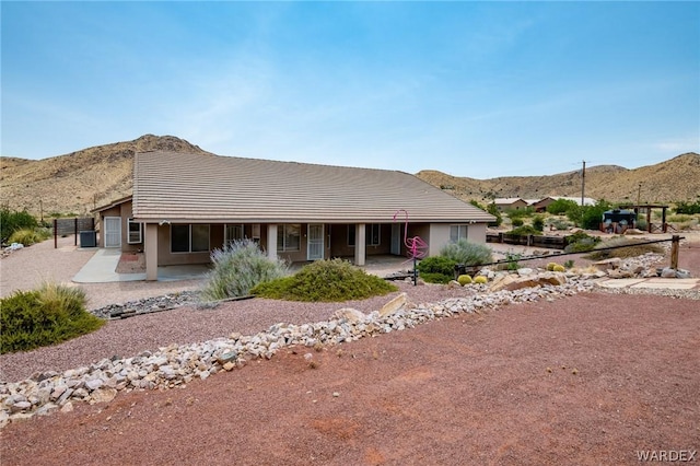 view of front facade with a patio area, a mountain view, and stucco siding