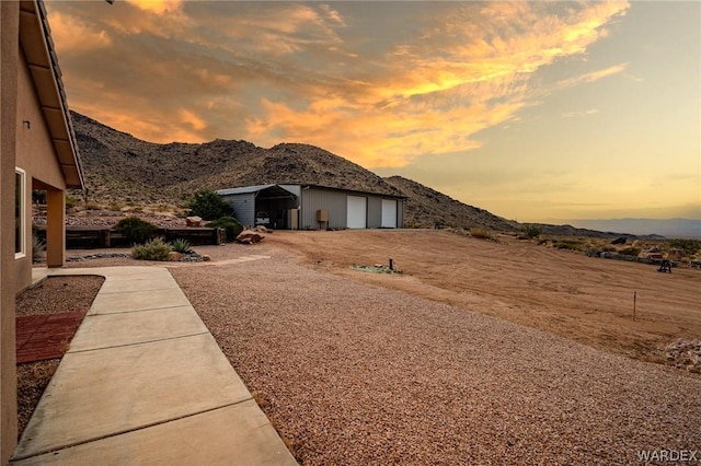 view of yard featuring an outdoor structure, a mountain view, and a detached garage