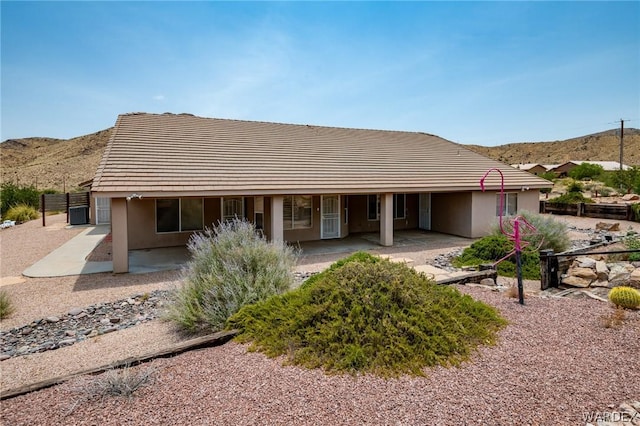 view of front of property with a patio area, a mountain view, and stucco siding