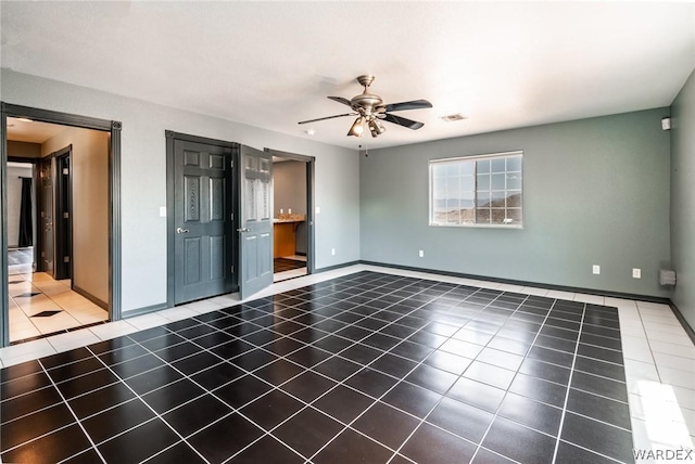 empty room with baseboards, tile patterned flooring, visible vents, and a ceiling fan