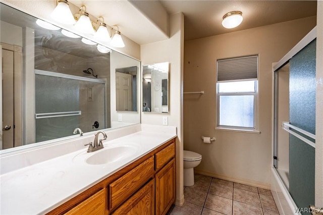 bathroom with baseboards, toilet, shower / bath combination with glass door, tile patterned flooring, and vanity