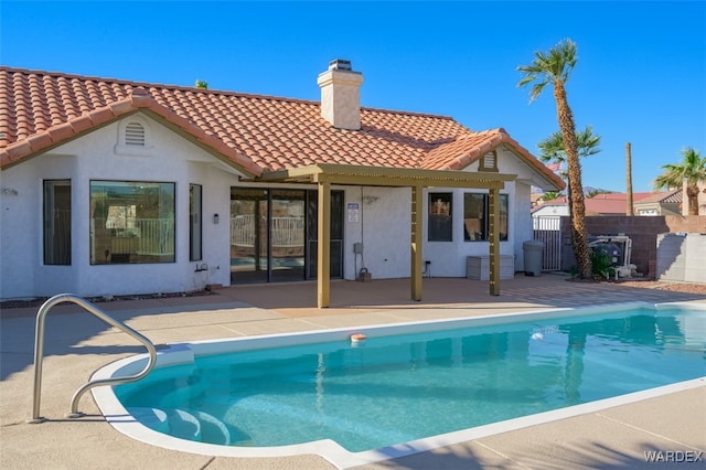 back of property with a patio, a tile roof, fence, stucco siding, and a chimney