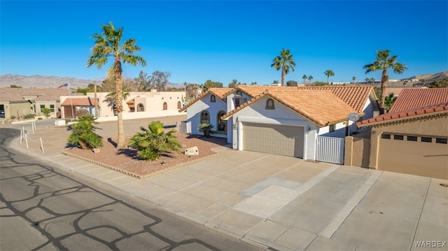 view of front of home featuring an attached garage, a mountain view, driveway, a residential view, and stucco siding