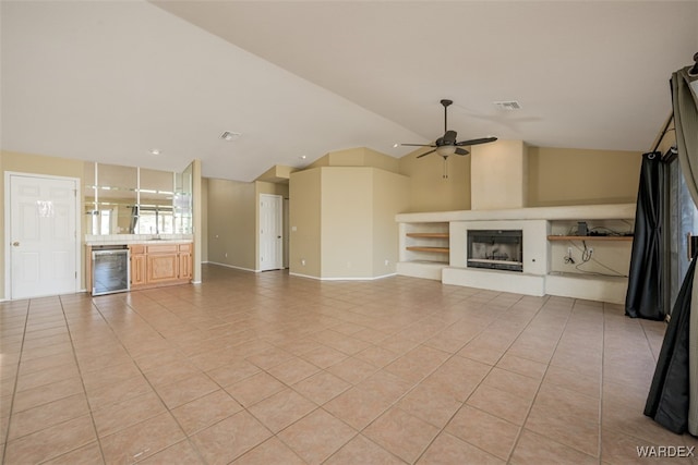 unfurnished living room featuring light tile patterned floors, wine cooler, visible vents, and a fireplace with raised hearth