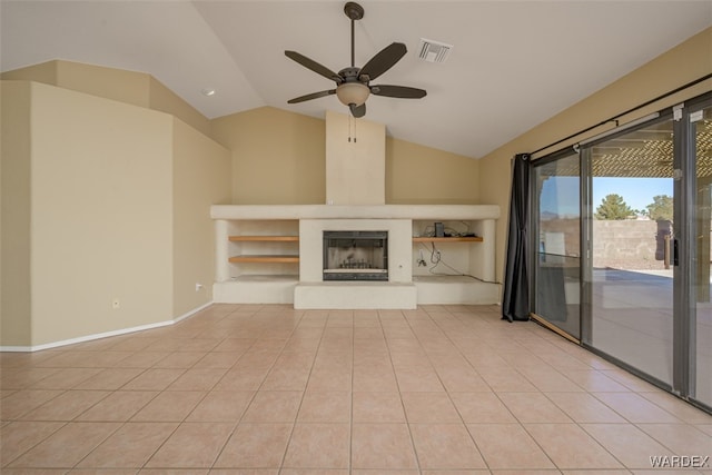 unfurnished living room with light tile patterned floors, visible vents, a fireplace with raised hearth, ceiling fan, and vaulted ceiling