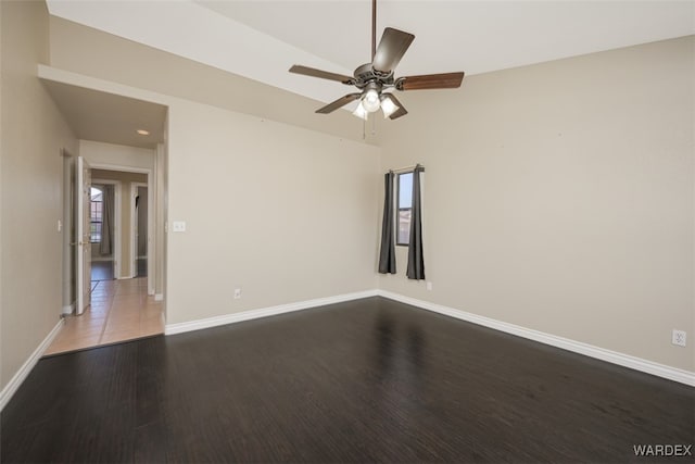 empty room with a ceiling fan, baseboards, and wood finished floors